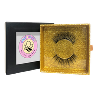 Thumbnail for Gold box with false eyelashes and a black box with a pink logo on a white background
